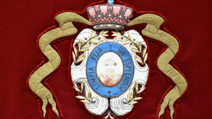 Detalle del escudo de la RAE en la mesa presidencial del salón de actos.